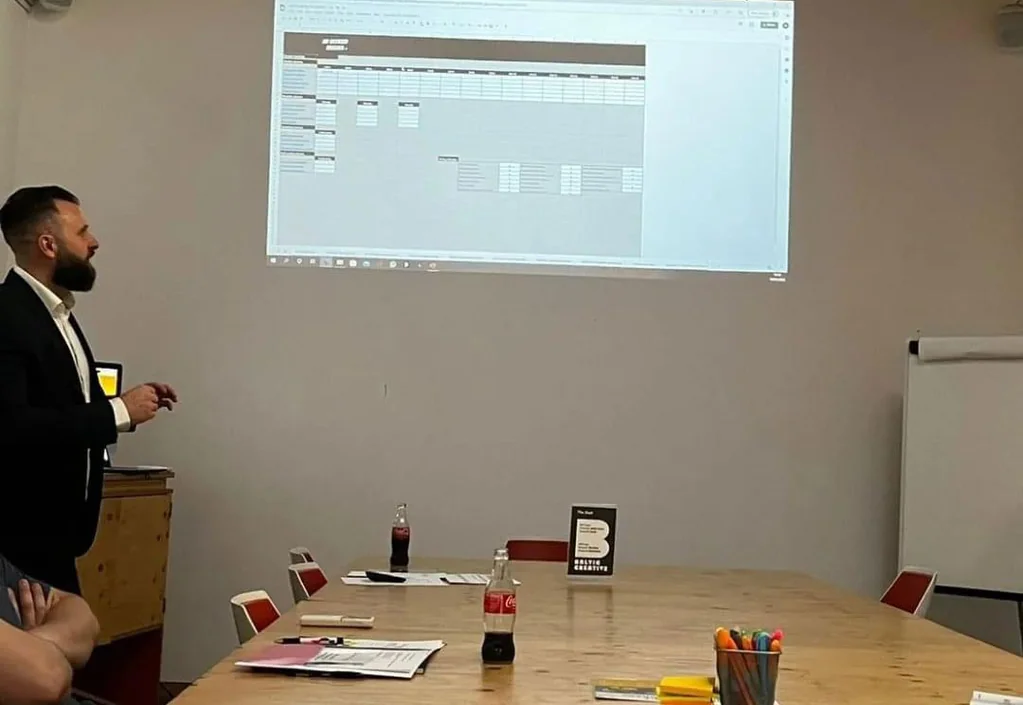 A trainer leading a session with a projected screen at a training centre